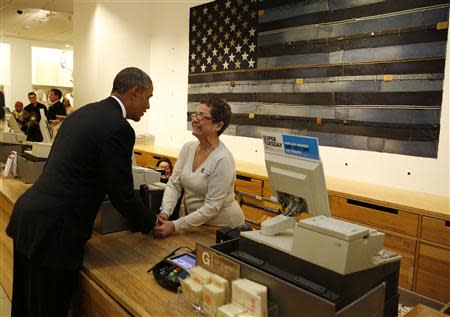 U.S. President Barack Obama shakes hands with cashier Sonia Del Gatto while he looks for gifts for his family after stopping off at the GAP in New York, March 11, 2014. REUTERS/Larry Downing