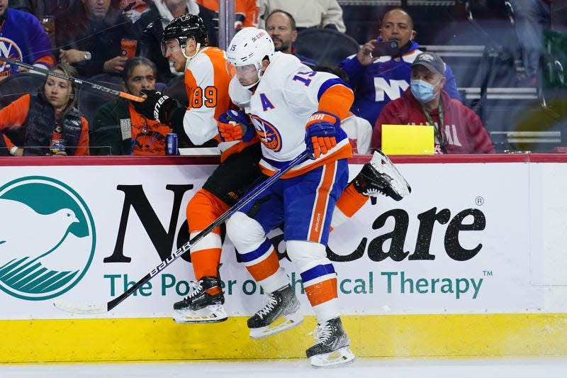 Philadelphia Flyers' Cam Atkinson, left, and New York Islanders' Cal Clutterbuck collide during the second period of an NHL hockey game, Tuesday, Jan. 18, 2022, in Philadelphia.