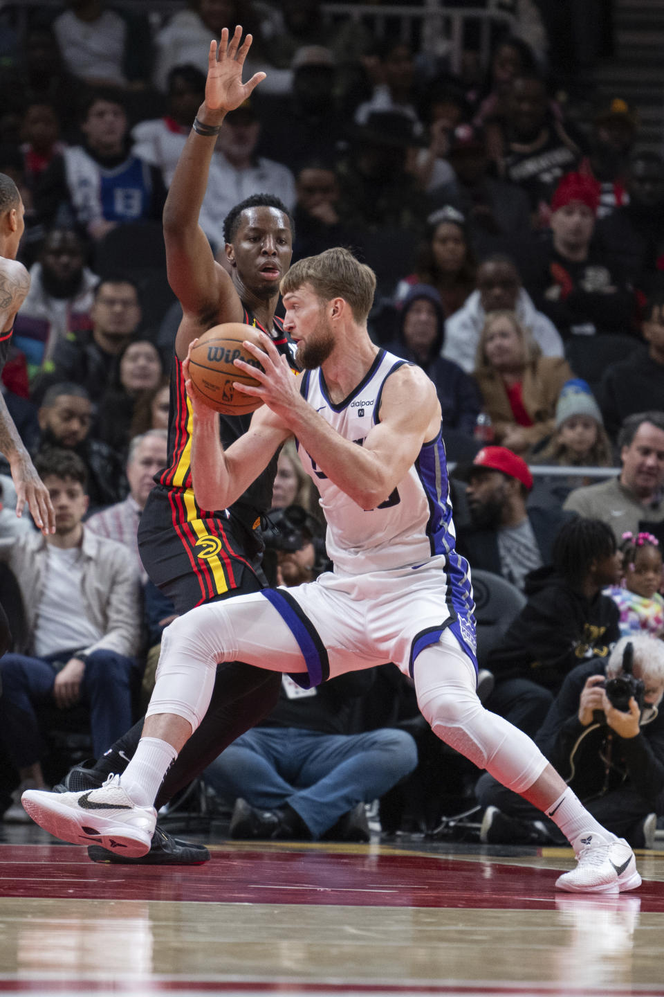 Sacramento Kings forward Domantas Sabonis (10) spins to the basket against Atlanta Hawks forward Onyeka Okongwu (17) during the first half of an NBA basketball game Friday, Dec 29, 2023, in Atlanta. (AP Photo/Hakim Wright Sr.)