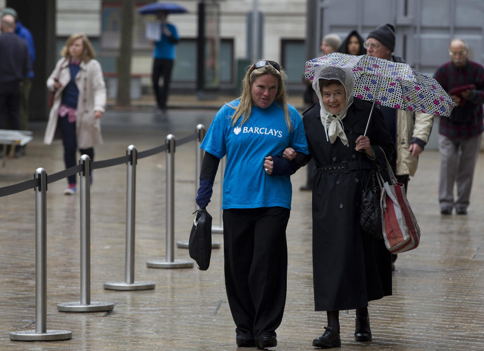 A member of Barclays Bank staff escorts a woman towards the entrance of the Royal Festival Hall where the Barclays Bank Annual General Meeting for shareholders is being held in London, Friday, April 27, 2012. Barclays PLC reported a 25 percent gain in first-quarter net profit on Thursday, beating market forecasts with strong performances in its retail and business banking, and wealth and investment management divisions. For the three months ending March 31, Barclays reported an adjusted profit after tax of 1.87 billion pounds ($3 billion) after taxes, compared to 1.5 billion pounds a year earlier. Income rose by 5 percent to 8.14 billion pounds.(AP Photo/Alastair Grant)