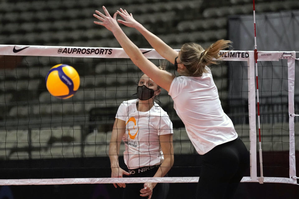 FILE - In this Feb. 24, 2021, file photo, Jordan Larson hits past defender Karsta Lowe, right, during a volleyball workout at Fair Park Coliseum, in Dallas. Larson was a player and coach while winning the inaugural championship of a unique women's professional indoor volleyball league focused on individual stats over team results. (AP Photo/Tony Gutierrez, File)