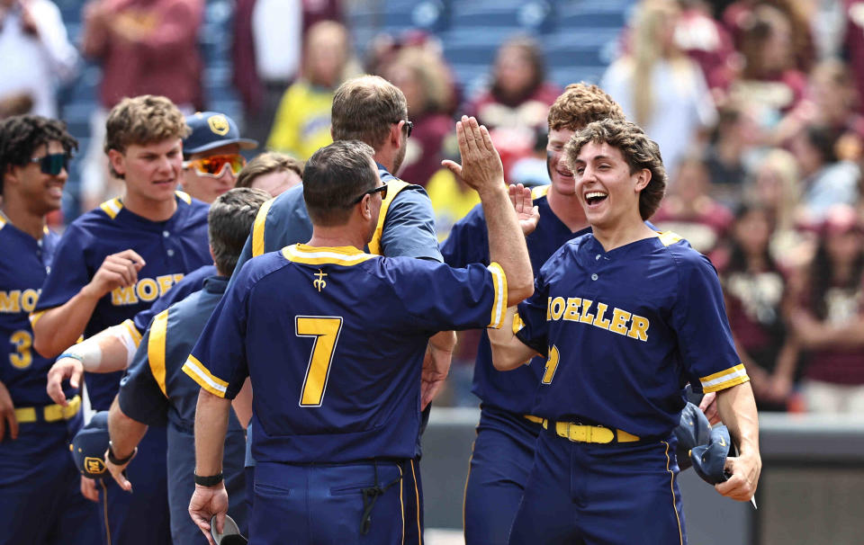 Moeller pitcher Carson Marsh (29) and head coach Tim Held celebrate after the Crusaders' 2-0 win over Walsh Jesuit in the OHSAA state baseball Final Four game Thursday, June 8, 2023.