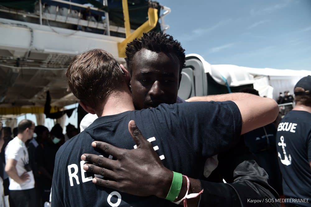 A migrant hugs a rescue team member before disembarking from the vessel Aquarius in Valencia: AFP