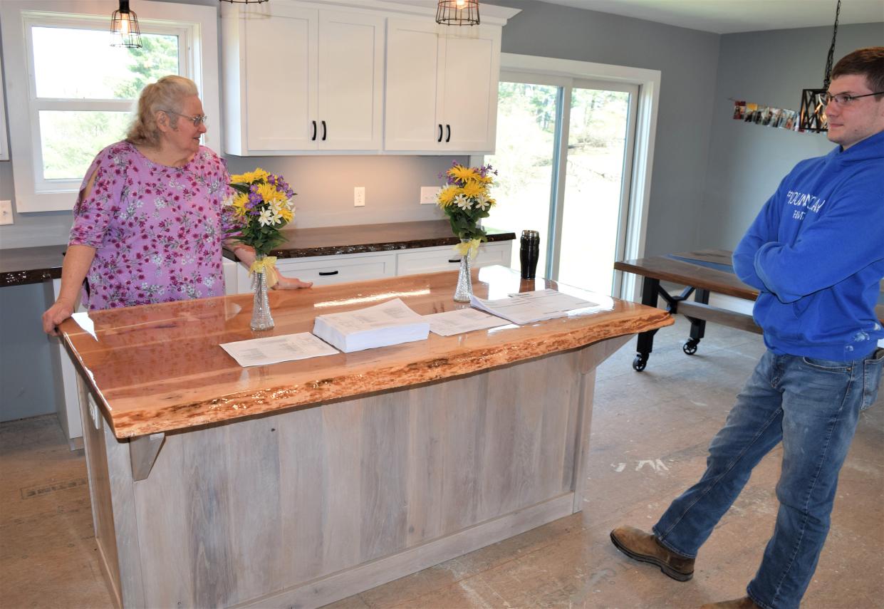 Judy Mengel admires the handiwork done by students like Dillon Miller (at right) in the custom built manufactured home the students built and will auction off on Thursday, May 12, at 6 p.m.