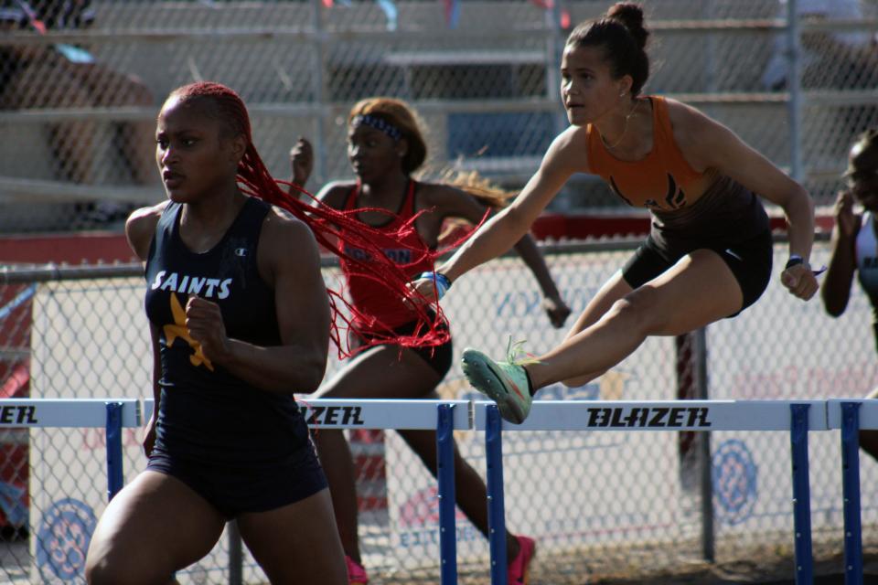 Sandalwood's Brittney Jennings leads the field as Atlantic Coast's Jordan Golden pursues during the girls 100-meter hurdles.