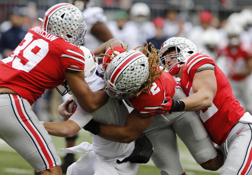 Ohio State defenders, left to right, Malik Harrison, Chase Young and Tuf Borland sack Penn State quarterback Sean Clifford during the first half of an NCAA college football game Saturday, Nov. 23, 2019, in Columbus, Ohio. (AP Photo/Jay LaPrete)