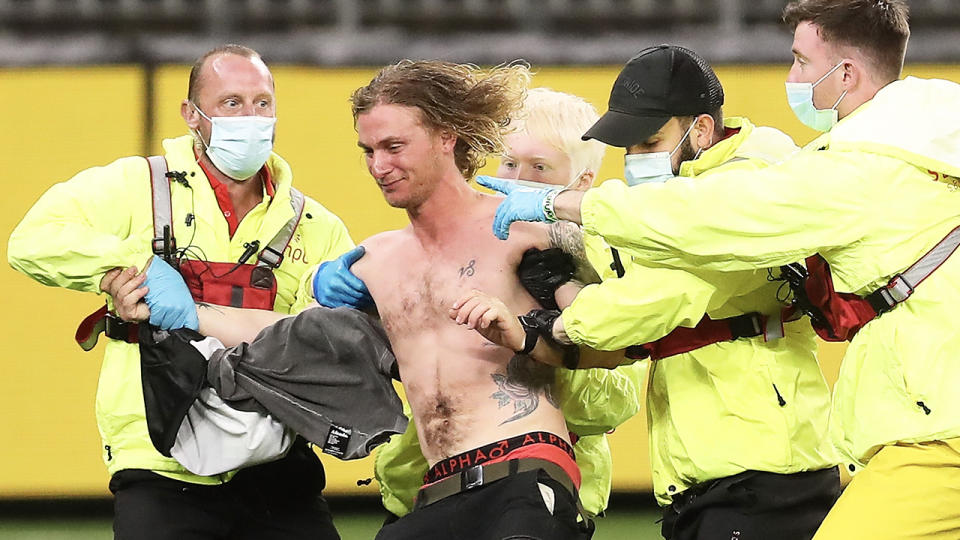 Victorian Jesse Hayen (pictured shirtless) being tackled by security.