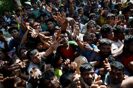 Rohingya refugees strech their hand for relief supplies given by local people in Cox’s Bazar, Bangladesh September 16, 2017. REUTERS/Mohammad Ponir Hossain