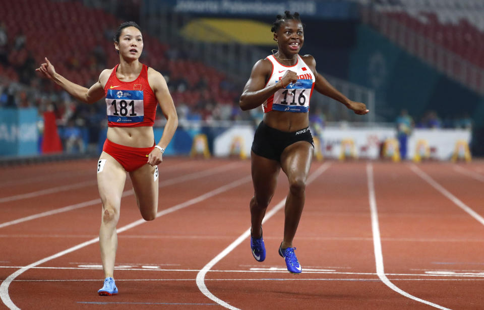 Bahrain's Edidiong Odiong, right, crosses the line to win the women's 100m final during the athletics competition at the 18th Asian Games in Jakarta, Indonesia, Sunday, Aug. 26, 2018. (AP Photo/Bernat Armangue)