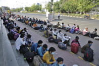 Migrant workers from other states trying to return to their homes wait for transportation to a train station in Ahmedabad, India, Sunday, May 17, 2020. Tens of thousands of migrant laborers have been returning from big cities to their villages after losing jobs because of a countrywide lockdown imposed in late March to contain the spread of the coronavirus. (AP Photo/Ajit Solanki)