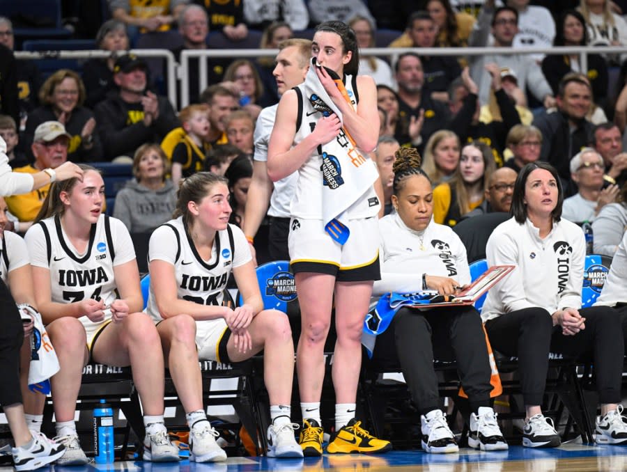 Iowa guard Caitlin Clark, center, takes a break on the sideline with teammates while playing against Colorado during the second half of a Sweet 16 college basketball game in the NCAA Tournament in Albany, N.Y. Saturday, March 30, 2024. Iowa won 89-68. (AP Photo/Hans Pennink)