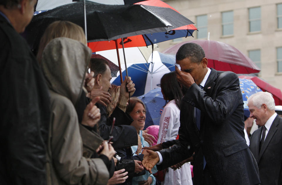 Barack Obama wipes the rain off his face as he meets Pentagon staff and family members of the victims of the September 11 attacks in a ceremony marking the eighth anniversary of the tragedy at the Pentagon in 2009. (Photo: Jim Young / Reuters)