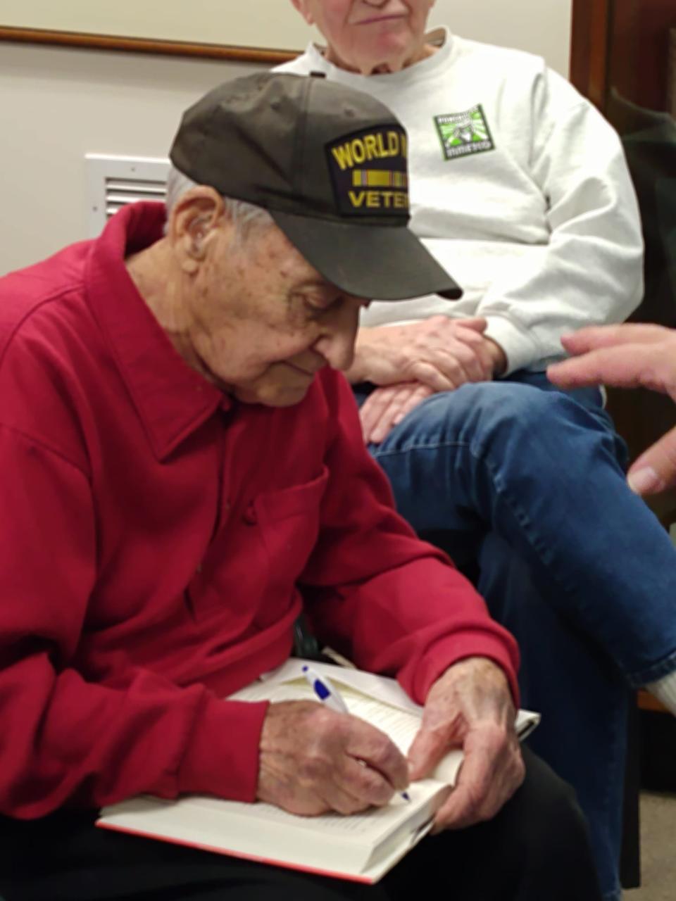 Local veteran Guy Prestia signed the copy of the book, as he was mentioned in it, and even wrote his military serial number into it as well.