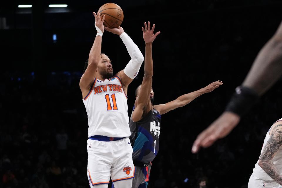 New York Knicks' Jalen Brunson (11) shoots a three-point shot as Brooklyn Nets' Mikal Bridges (1) defends during the first half of an NBA basketball game Wednesday, Dec. 20, 2023, in New York. (AP Photo/Frank Franklin II)