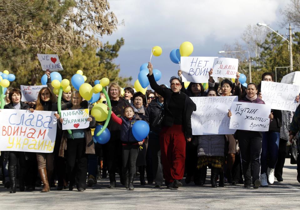 Participants hold placards and shout slogans during an anti-war rally in the Crimean town of Bakhchisaray