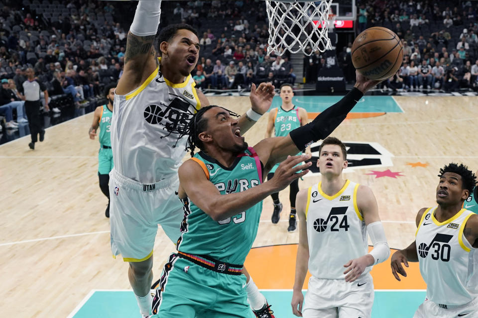 San Antonio Spurs guard Tre Jones drives to the basket against Utah Jazz forward Juan Toscano-Anderson during the first half of an NBA basketball game in San Antonio, Wednesday, March 29, 2023. (AP Photo/Eric Gay)