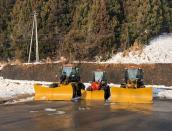 Snow ploughs are parked near a snow resort in Iiyama