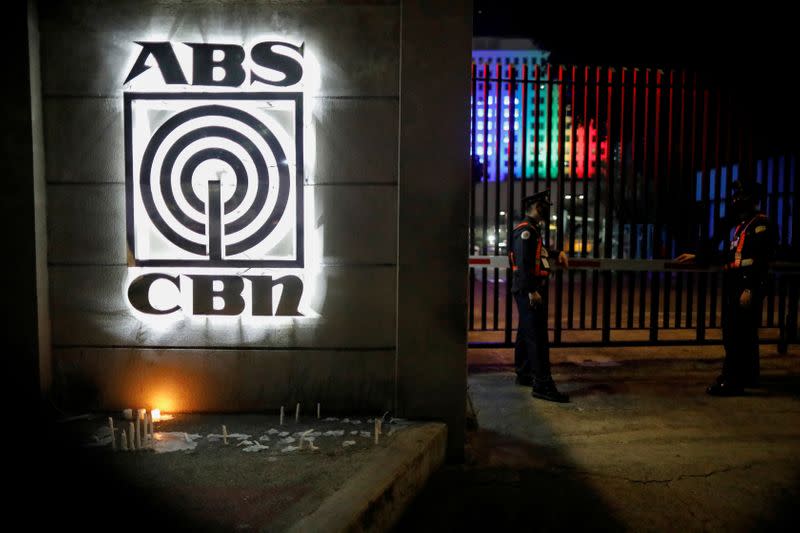 FILE PHOTO: Security guards stand outside the headquarters of ABS-CBN network following government orders to cease its operations, in Quezon City