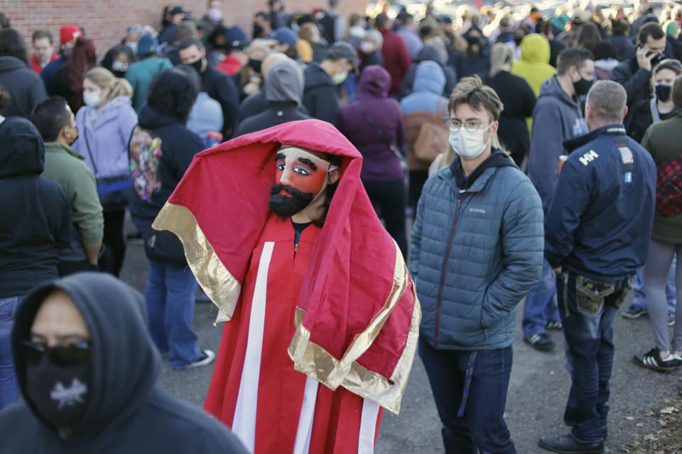 Adam Fogerty wears a costume on Halloween, as he stands in line with others to vote early, at the Douglas County Election Commission office in Omaha, Neb., Saturday, Oct. 31, 2020. (AP Photo/Nati Harnik)