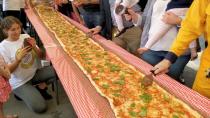People cut a 100m long margherita pizza made by Pellegrini's Italian restaurant as part of a charity event to race funds for the New South Wales Rural Fire Service, In Sydney, Australia