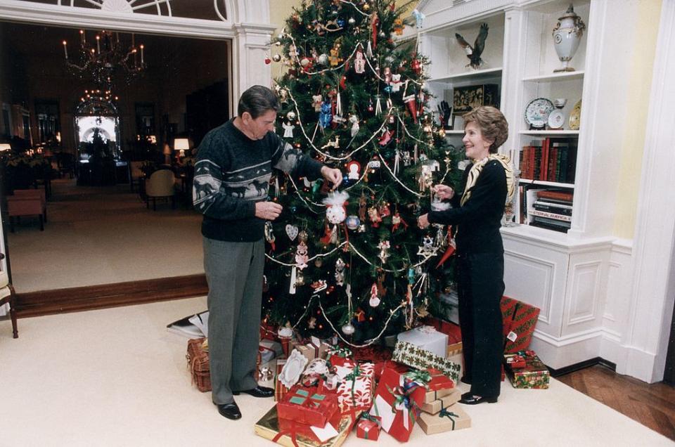 US President Ronald Reagan and First Lady Nancy Reagan decorate the White House Christmas tree, 24 December 1983. (Photo by Ronald Reagan Library/Getty Images) | Ronald Reagan Library—Getty Images