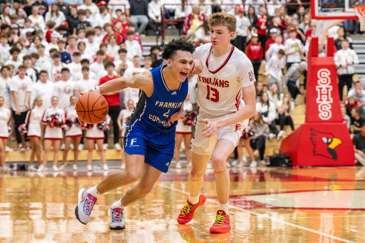 Franklin Community High School senior Micah Davis (4) makes a move around the defense of Center Grove High School freshman Gavin Loveless (13) during the second half of an IHSAA Class 4A Boys Regional basketball game, Saturday, March 9, 2024, at Southport High School. Center Grove won, 68-56.