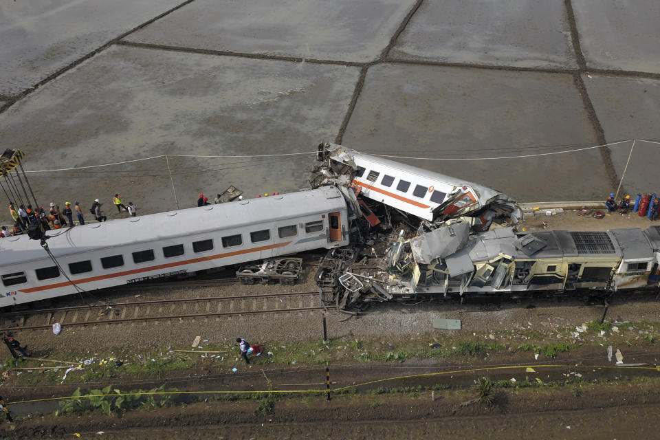 Rescuers inspect the wreckage after a collision between two trains in Cicalengka, West Java, Indonesia, Friday, Jan. 5, 2024. The trains collided on Indonesia's main island of Java on Friday, causing several carriages to buckle and overturn, officials said. (AP Photo/Achmad Ibrahim)