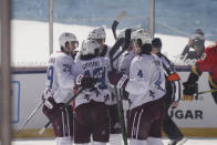 CORRECTS STATE TO NEVADA-Colorado Avalanche defenseman Samuel Girard (49) is surrounded by his teammates after scoring during the first period against the Vegas Golden Knights, at the Outdoor Lake Tahoe NHL hockey game in Stateline, Nev., Saturday, Feb. 20, 2021. (AP Photo/Rich Pedroncelli))