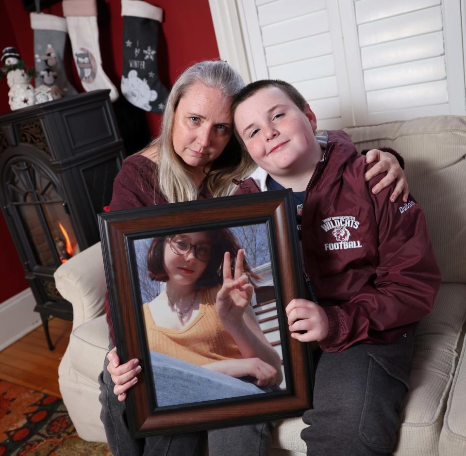 Tracy DuBois, left, the mother of Bella DuBois, and Thomas DuBois, 11, Bella's brother, hold photographs of the late Bella at their home in West Bridgewater on Wednesday, Dec. 14, 2022. Bella succumbed to osteosarcoma, a rare form of bone cancer, on Dec. 8.