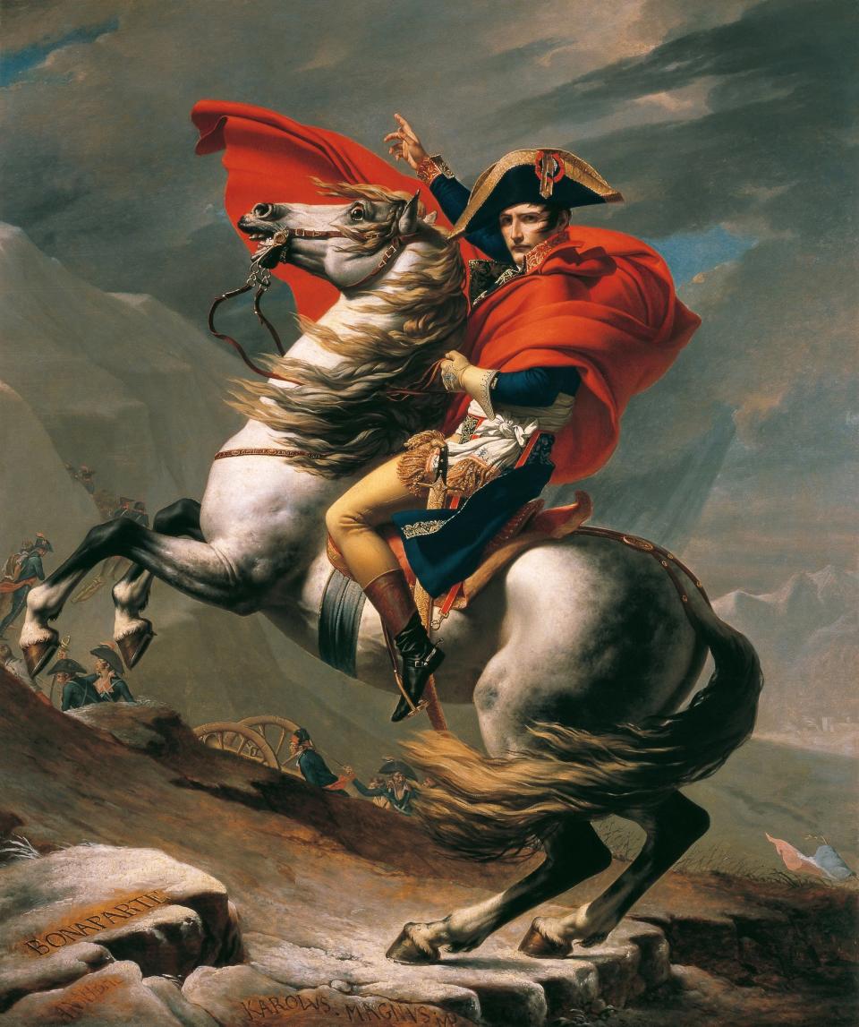 Napoleon Bonaparte on horseback gesturing forward against a dramatic sky, depicted in Jacques-Louis David's painting