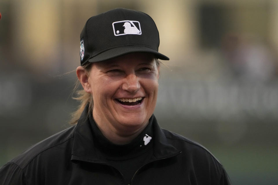 Umpire Jen Pawol smiles as she takes part in the lineup card exchange before the start of a spring training baseball game between the Washington Nationals and the Houston Astros Saturday, Feb. 24, 2024, in West Palm Beach, Fla. Pawol took a big step toward breaking the gender barrier for Major League Baseball umpires when she became the first woman in 17 years to work a big league spring training game Saturday night. (AP Photo/Jeff Roberson)
