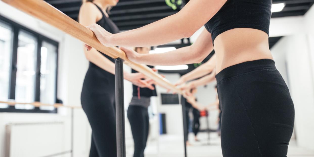 Group of women standing by the barre at pilates class