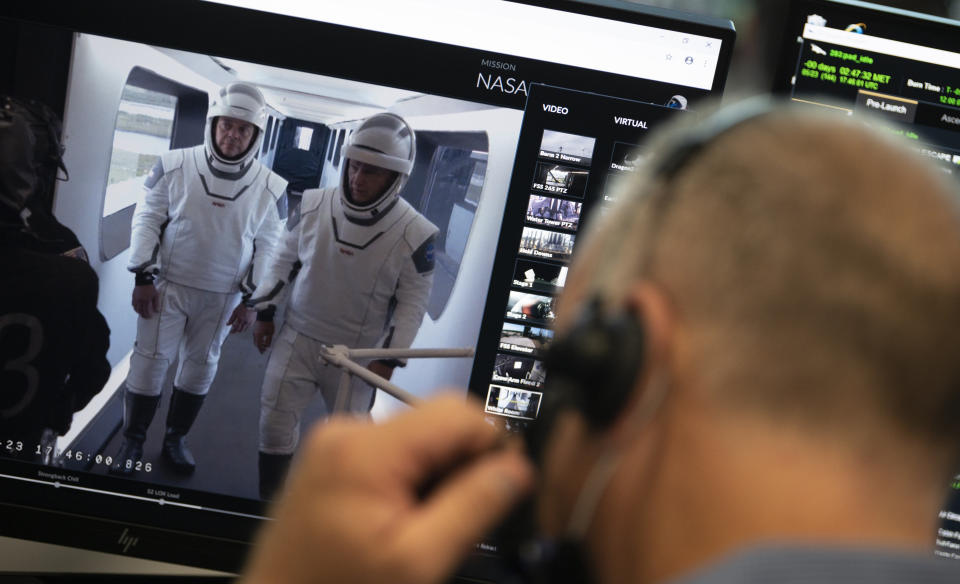 NASA astronauts Robert Behnken, left, and Douglas Hurley, right, are seen on a monitor showing the crew access arm at Launch Complex 39A during a dress rehearsal prior to the Demo-2 mission launch, Saturday, May 23, 2020, at NASA's Kennedy Space Center in Cape Canaveral, Fla. The SpaceX Falcon 9 rocket, that will send two astronauts to the International Space Station for the first crewed flight from the U.S. in nearly a decade., is scheduled for launch on Wednesday, May 27. (Joel Kowsky/NASA via AP)