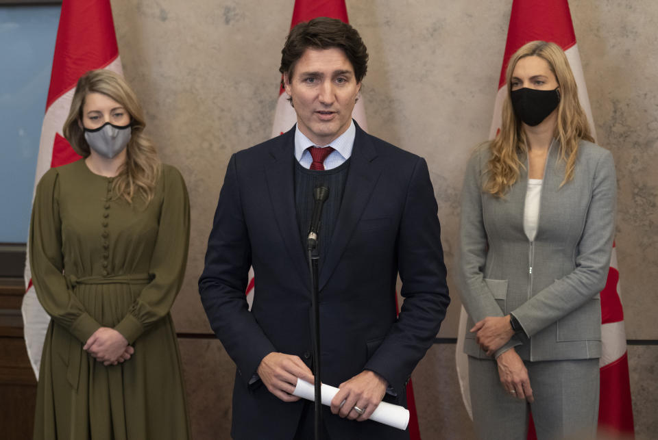 Canadian Prime Minister Justin Trudeau announces Canada will join a diplomatic boycott of the Beijing Winter Olympics over human rights concerns in Ottawa, Ontario, Wednesday, Dec. 8, 2021. Looking on are Foreign Affairs Minister Melanie Joly, left, and Sport Minister Pascale St-Onge (Adrian Wyld/The Canadian Press via AP)