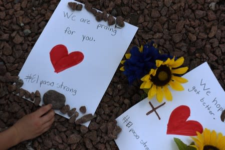 People pay their respects a day after a mass shooting in El Paso