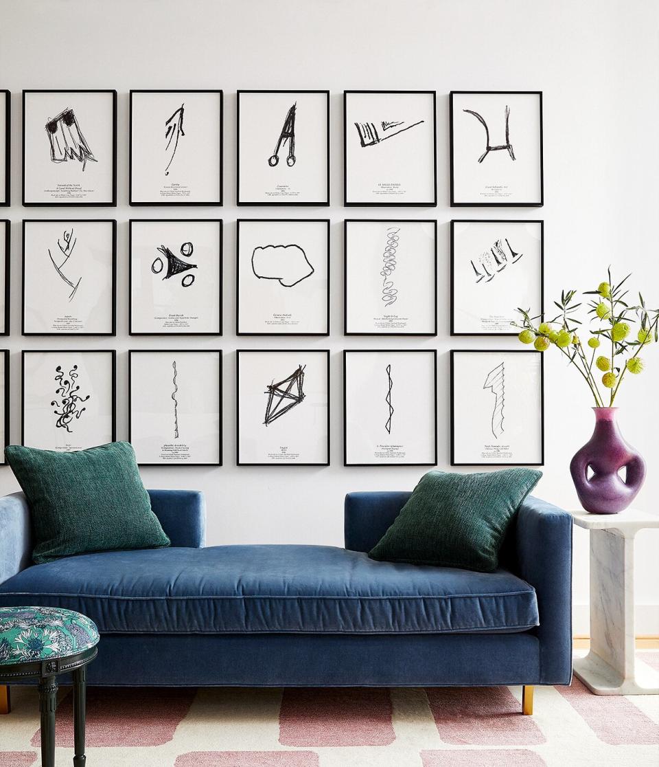 modern art sketches above blue couch in living room