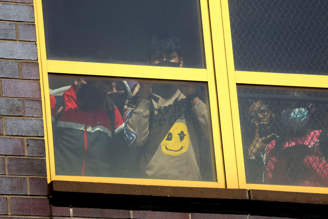 Children look out from a window near the scene of a shooting at a subway station in the Brooklyn borough of New York City