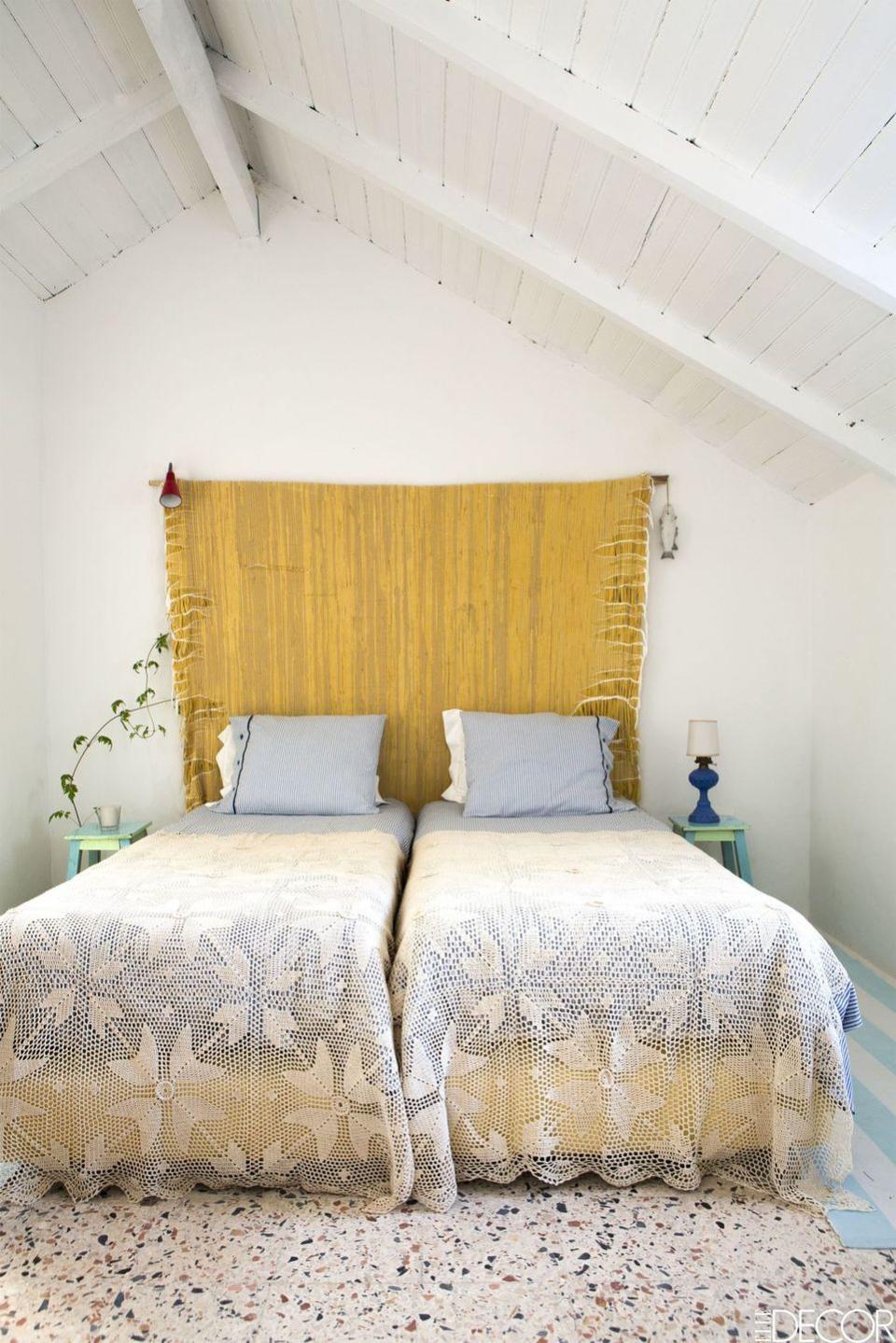 bohemian bedroom with two adjoining beds dressed in crocheted cotton coverlets