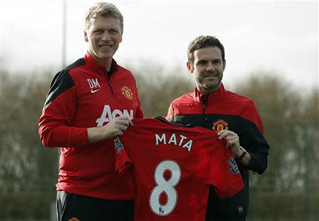 Manchester United's new signing Juan Mata (R) holds a club shirt with club manager David Moyes during a photocall at the club's Carrington training complex in Manchester, northern England, January 27, 2014. REUTERS/Phil Noble