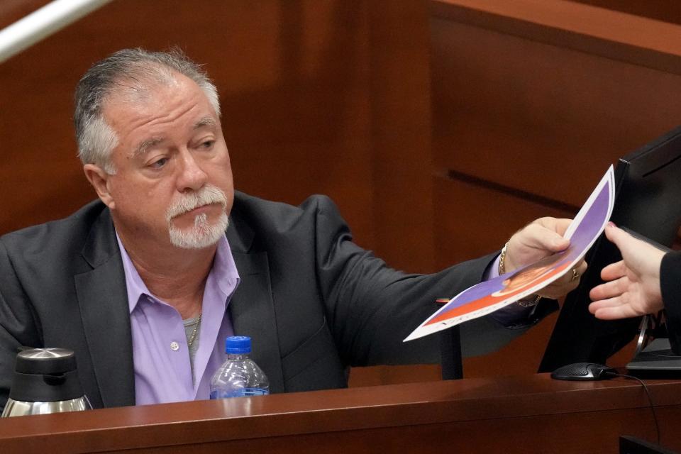 Retired Westglades Middle School principal John Vesey hands back a photograph of Marjory Stoneman Douglas High School shooter Nikolas Cruz to Assistant Public Defender Tamara Curtis, not shown, while testifying in the penalty phase of the trial of Marjory Stoneman Douglas High School shooter Nikolas Cruz at the Broward County Courthouse in Fort Lauderdale on Thursday, Sept. 1, 2022. Cruz previously plead guilty to all 17 counts of premeditated murder and 17 counts of attempted murder in the 2018 shootings.