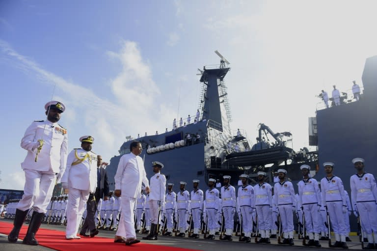 Sri Lankan President Maithripala Sirisena (C) inspects a guard of honour by navy sailors during the commissioning of a new off shore patrol vessel at Colombo's port on August 2, 2017