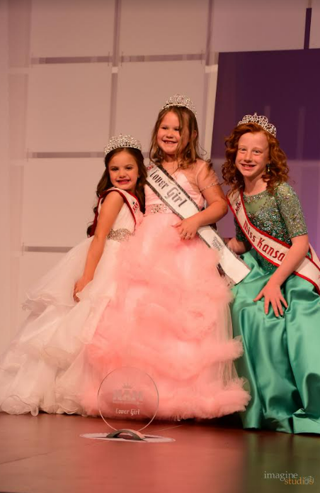 Six-year-old Bentlee Graham, center, poses for a photo after her crowning as National American Little Miss Missouri Covergirl Princess at the Holiday Inn Executive Center in Columbia in July 2023.