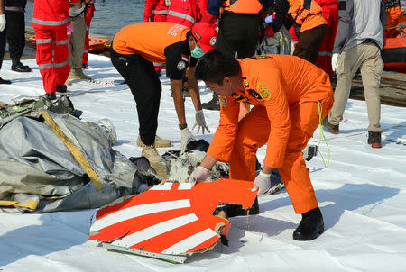 Rescue team members arrange the wreckage, showing part of the logo of Lion Air flight JT610, that crashed into the sea, at Tanjung Priok port in Jakarta, Indonesia. REUTERS/Stringer