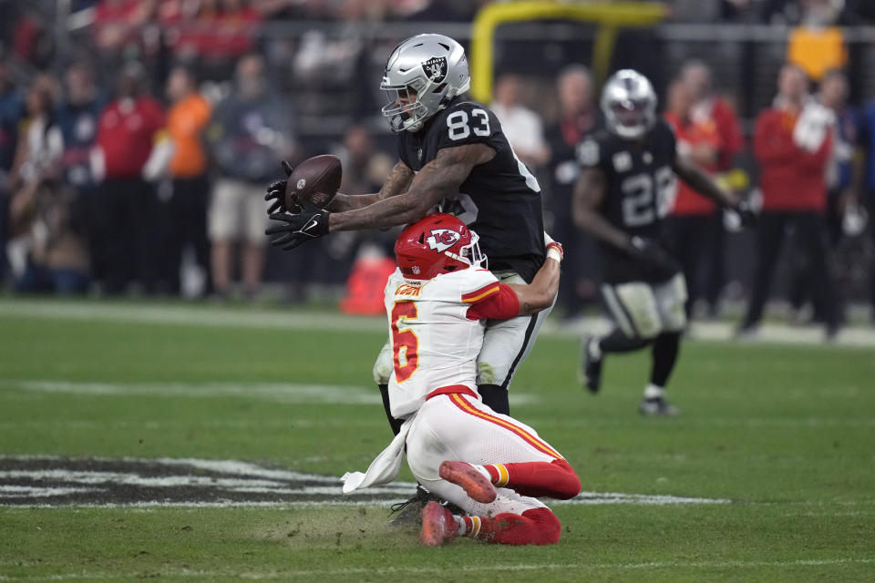 Las Vegas Raiders tight end Darren Waller (83) catches a pass over Kansas City Chiefs safety Bryan Cook (6) during the second half of an NFL football game Saturday, Jan. 7, 2023, in Las Vegas. (AP Photo/John Locher)