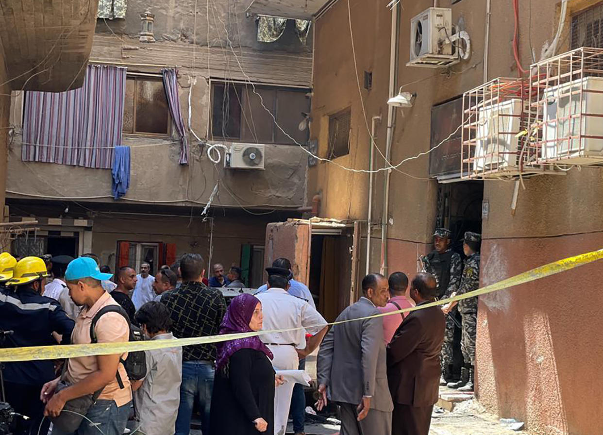 Emergency personnel work at the site of a fire at the Abu Sefein church that has killed over 40 people and injured at least 14 others, in the densely populated neighborhood of Imbaba, Cairo Egypt, Sunday, Aug. 14, 2022. The church said the fire broke out while a service was underway. The cause of the blaze was not immediately known but a Police said an initial investigation blamed an electrical short-circuit. (AP Photo/Mohamed Salah)