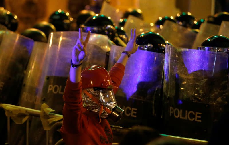 A protester gestures in front of a row of riot police officers during anti government protests in Beirut