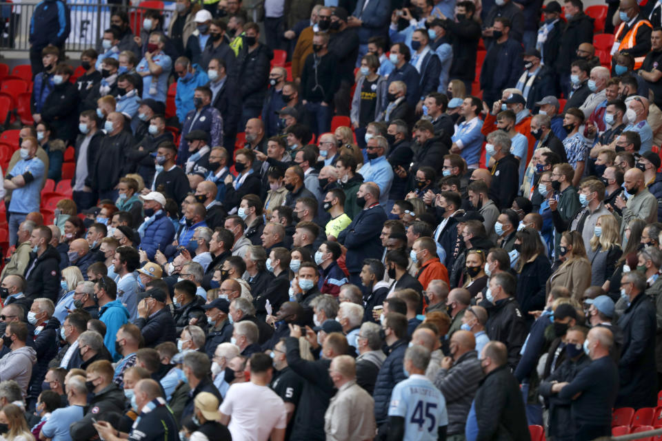 Hinchas del Manchester City de pie durante la final de la Copa de la Liga inglesa contra Tottenham, el domingo 25 de abril de 2021, en el estadio Wembley. (AP Foto/Alastair Grant)