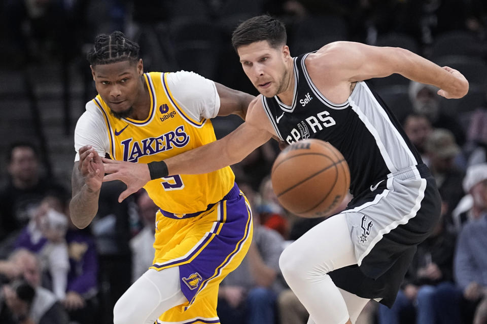 Los Angeles Lakers forward Cam Reddish, left, knocks the ball away from San Antonio Spurs forward Doug McDermott, right, during the first half of an NBA basketball game in San Antonio, Wednesday, Dec. 13, 2023. (AP Photo/Eric Gay)