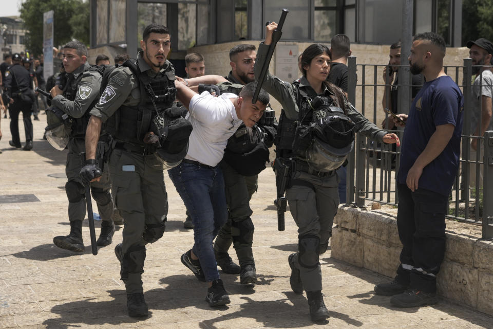 Members of Israeli security forces detain a Palestinian protester near Damascus Gate outside Jerusalem's Old City as Israelis mark Jerusalem Day, an Israeli holiday celebrating the capture of the Old City during the 1967 Mideast war. Sunday, May 29, 2022. Israel claims all of Jerusalem as its capital. But Palestinians, who seek east Jerusalem as the capital of a future state, see the march as a provocation. Last year, the parade helped trigger an 11-day war between Israel and Gaza militants. (AP Photo/Mahmoud Illean)