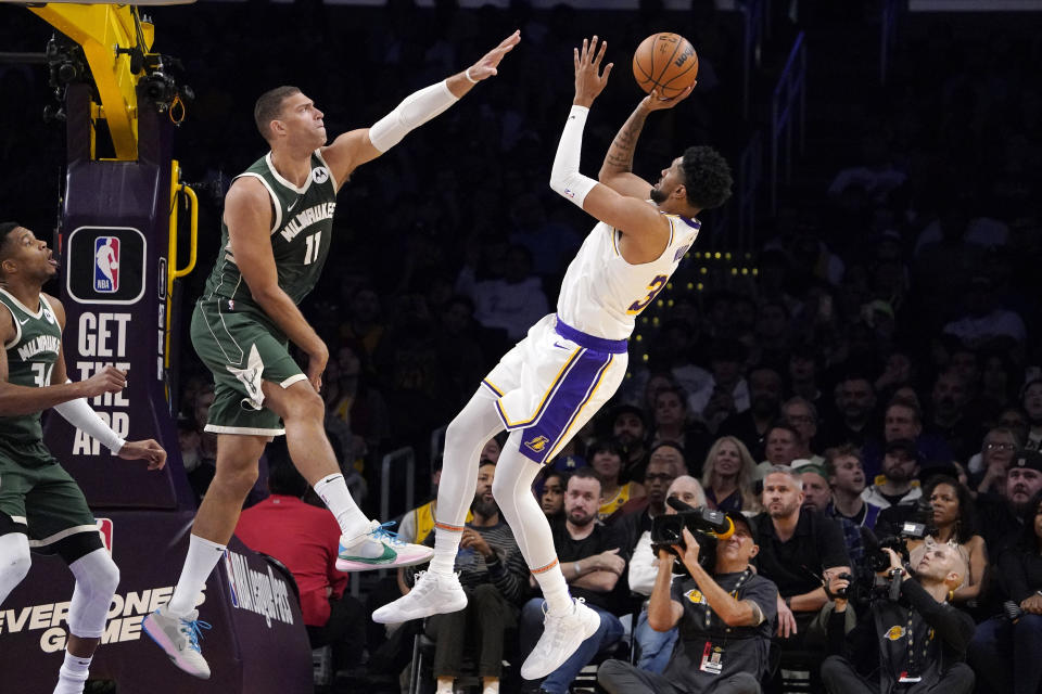 Los Angeles Lakers forward Christian Wood, right, shoots as Milwaukee Bucks center Brook Lopez, center, defends and forward Giannis Antetokounmpo watches during the first half of an NBA preseason basketball game Sunday, Oct. 15, 2023, in Los Angeles. (AP Photo/Mark J. Terrill)